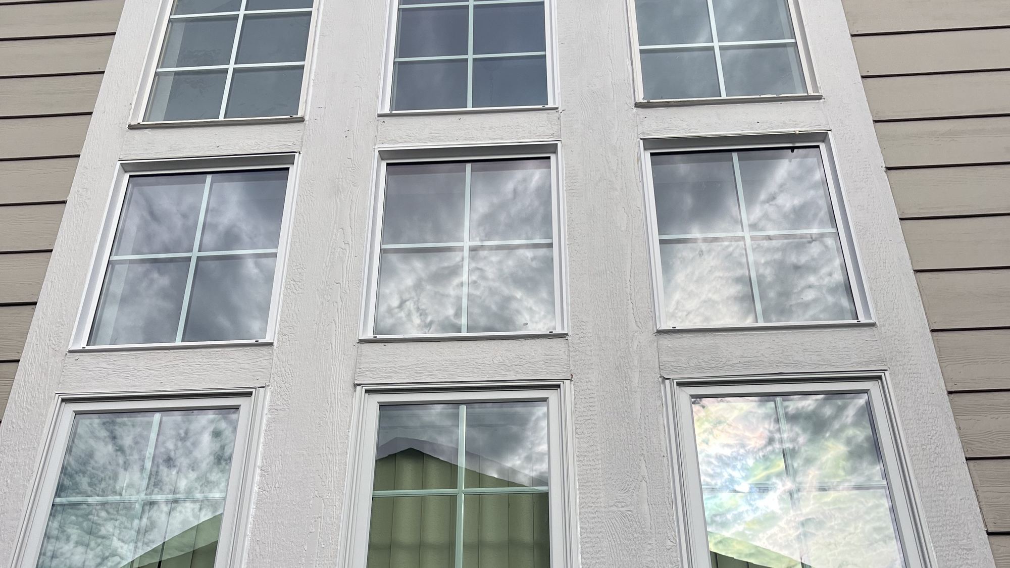 Tall arched multi-lite window on a stucco home