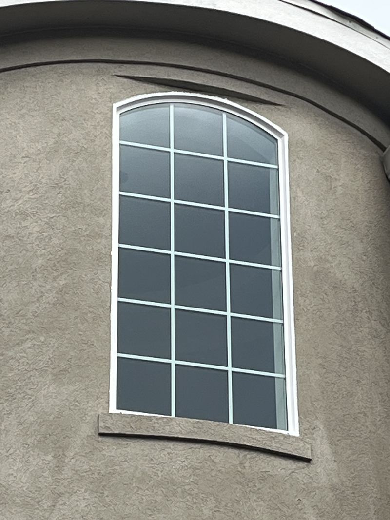 Arched grid window in stucco