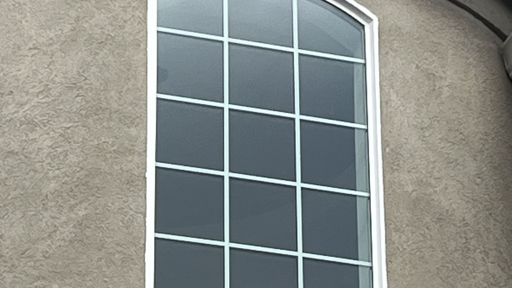 Arched grid window in stucco