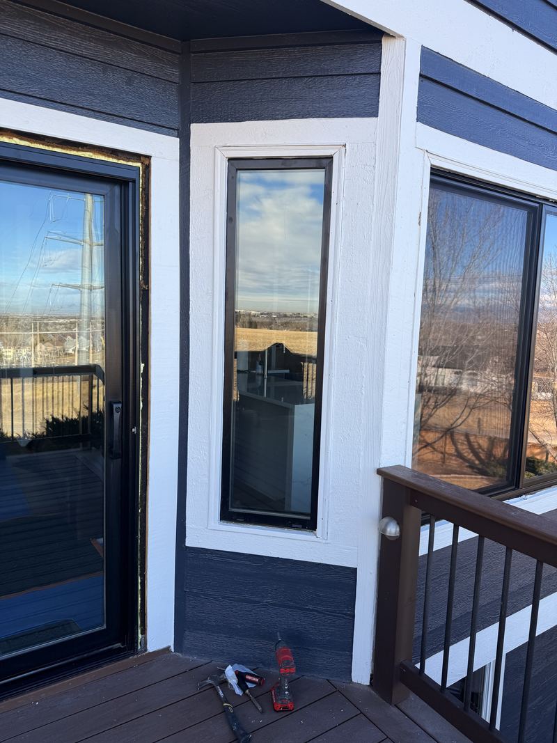Black window and door on a deck with a view