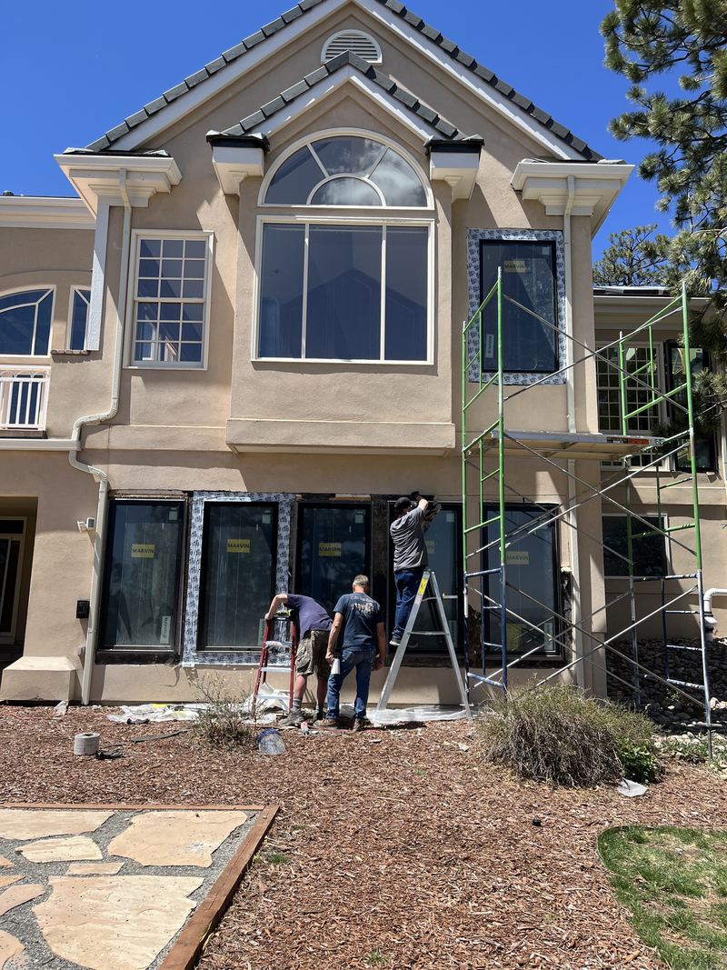 Scaffold on a large stucco home during whole-house replacement