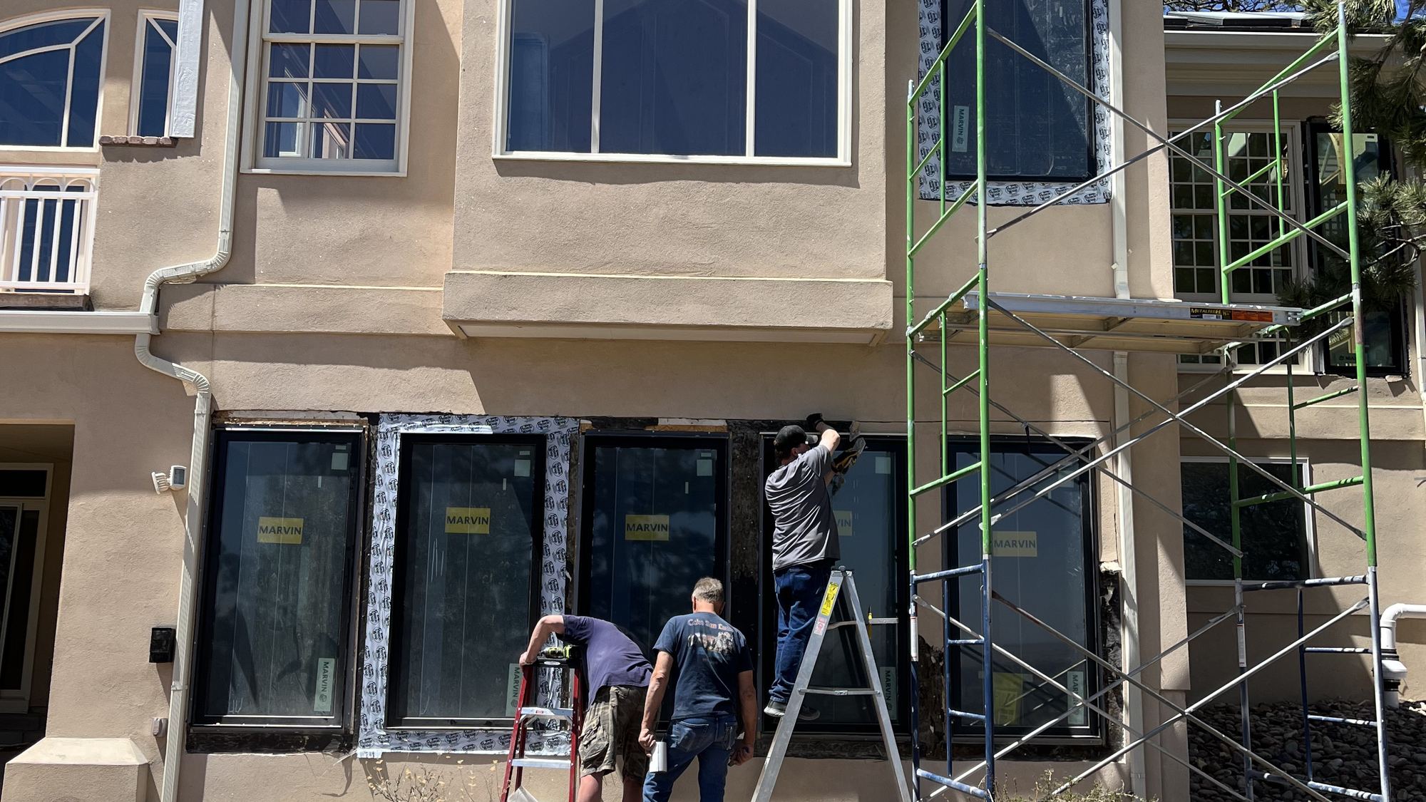 Scaffold on a large stucco home during whole-house window replacement