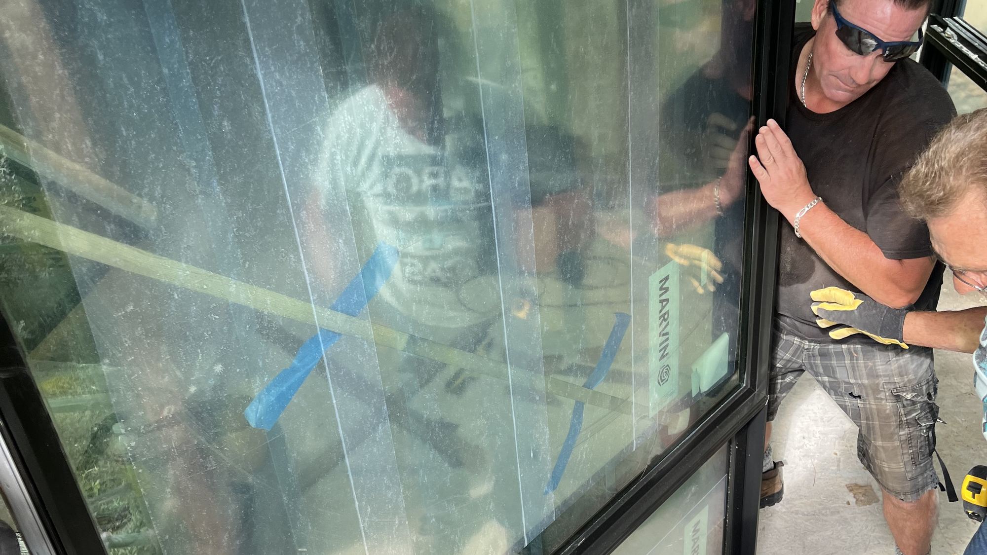 Installer guiding a large glass unit into place