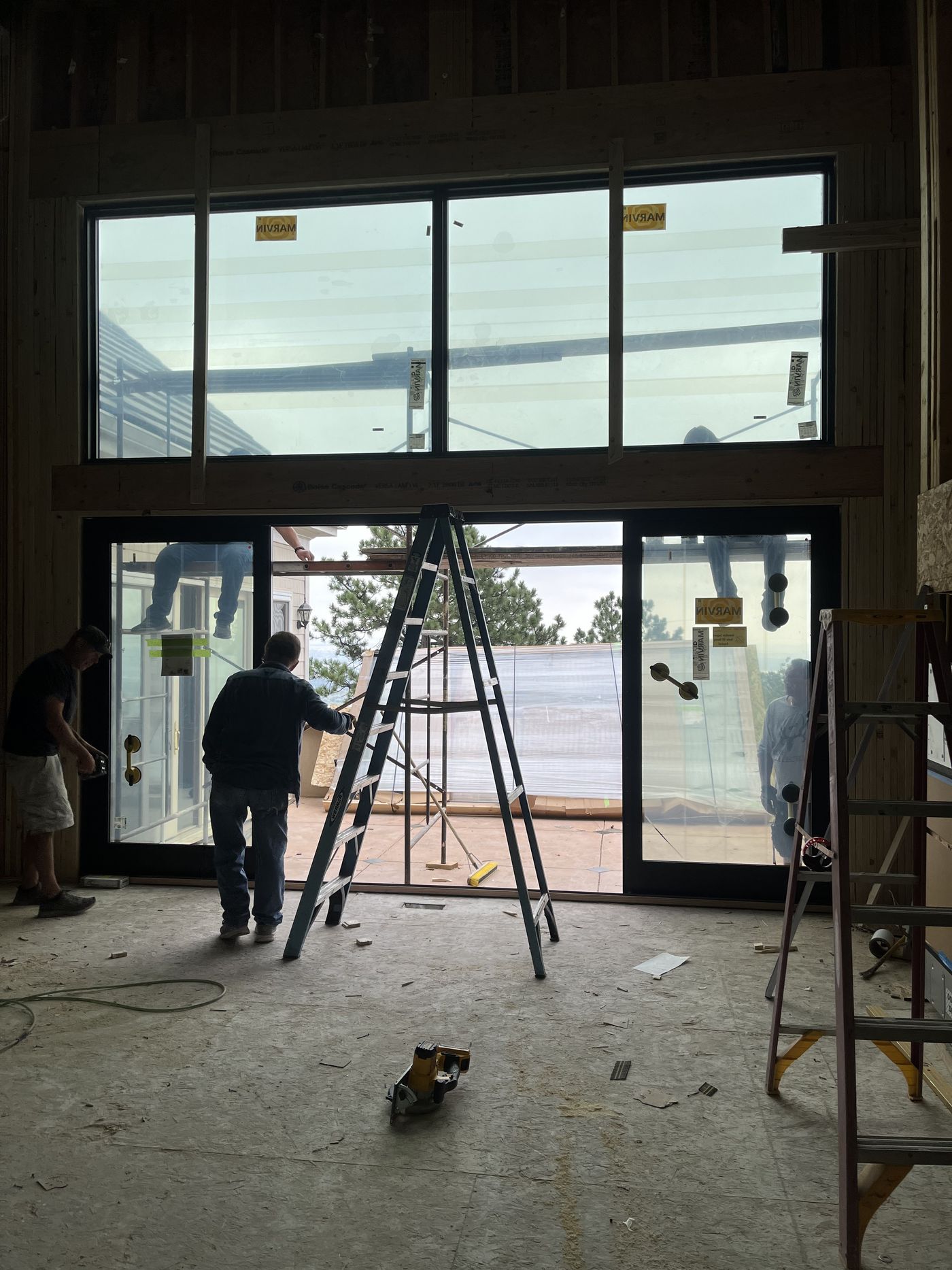 Crew positioning a large glass unit in a framed opening