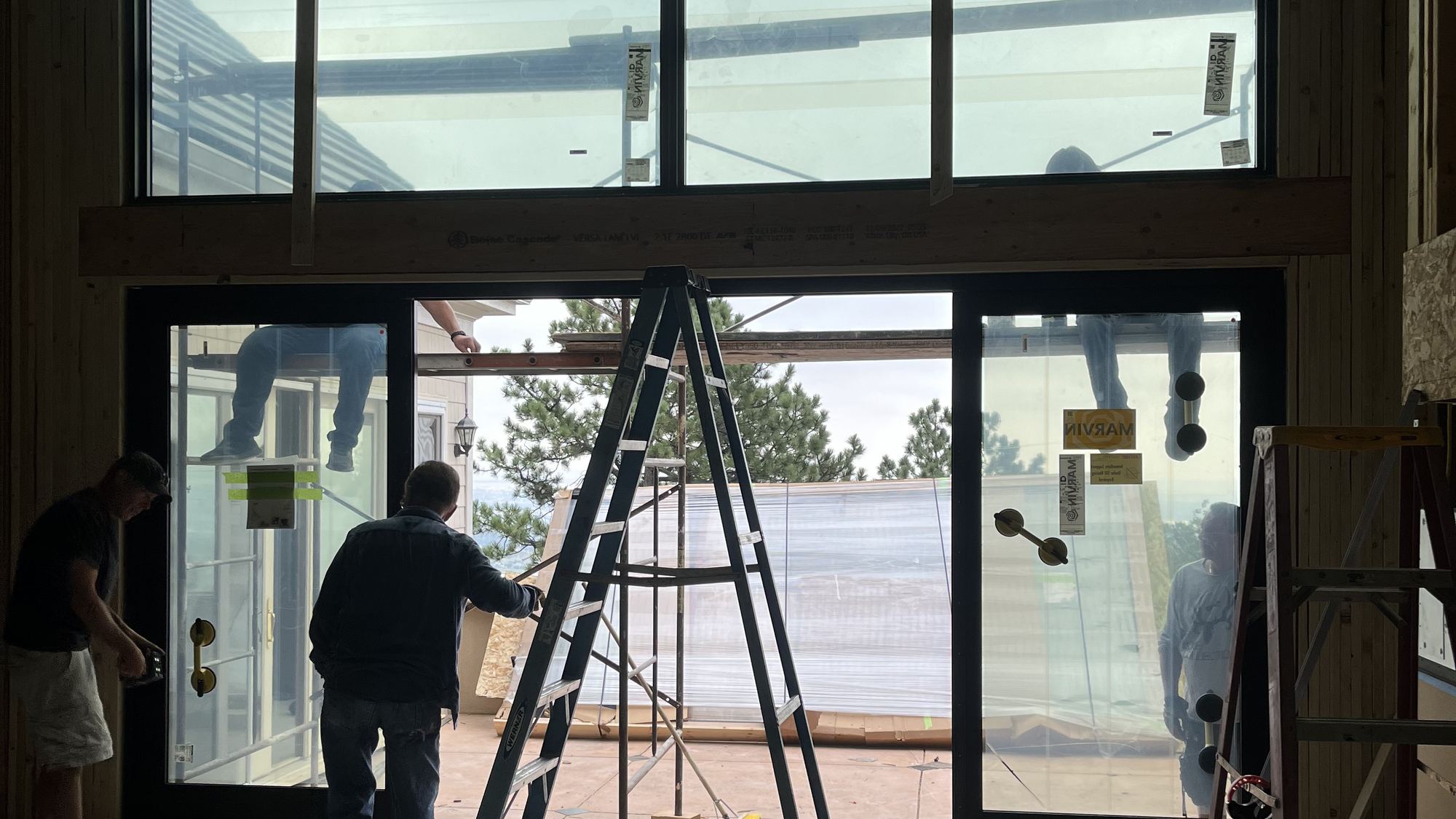 Crew positioning a large glass unit in a framed opening