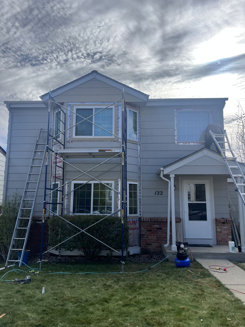 Two-story house with scaffold during window replacement