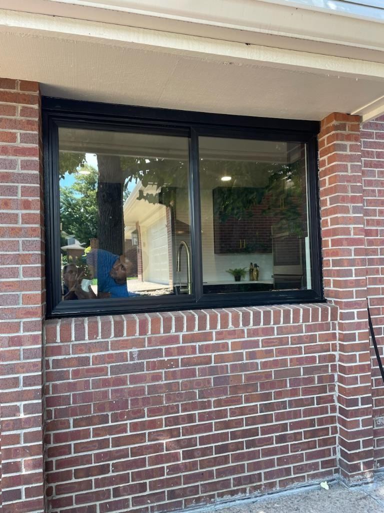 Black-frame picture window set in brick