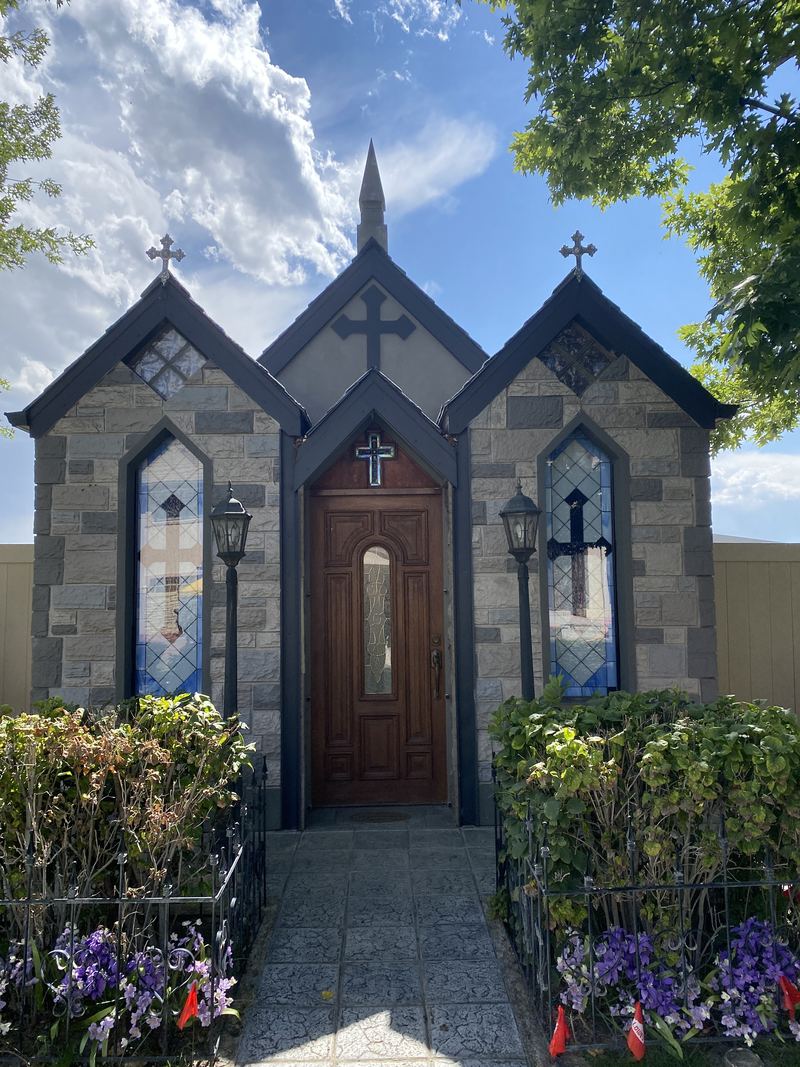 Stone chapel with stained-glass windows and a new wood entry door