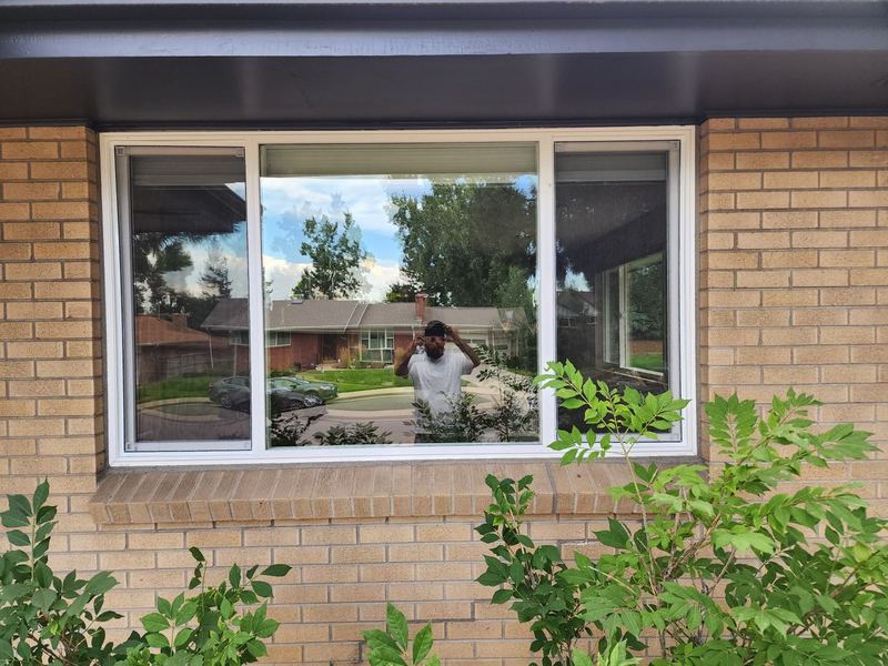 White picture window on brick with landscaping