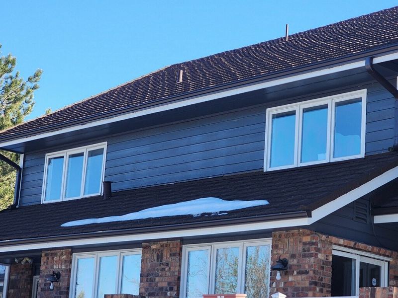 Dark modern home with many new windows in snow